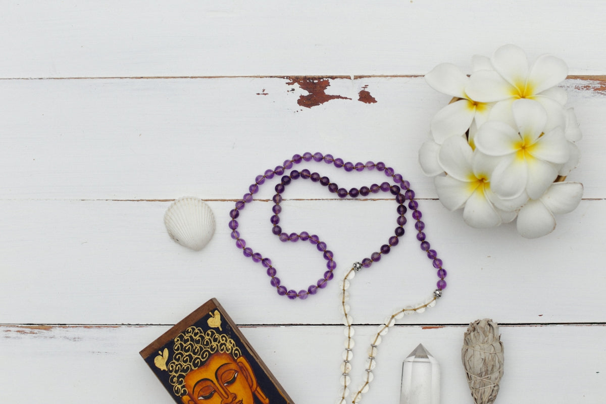 a rosary, a candle, a flower and a picture on a table
