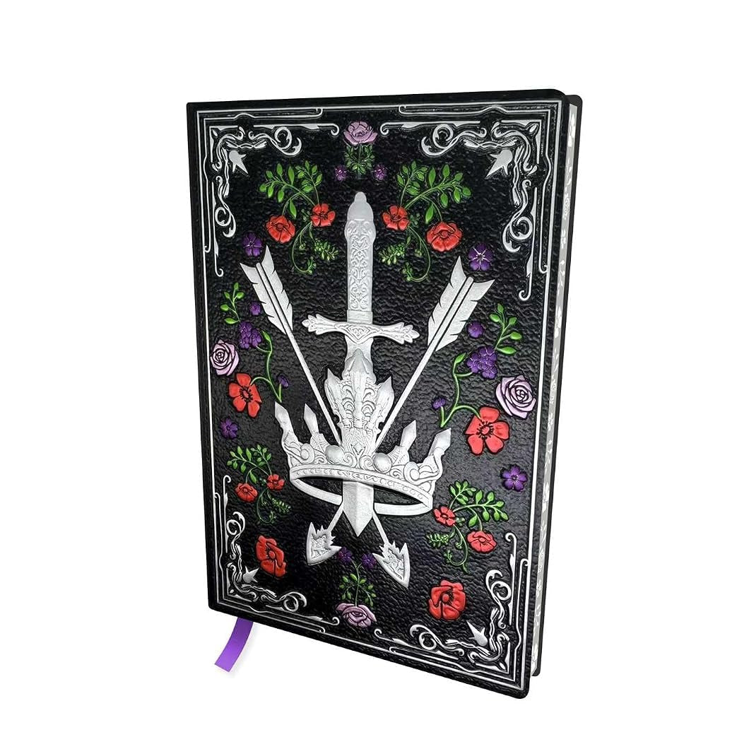A black hardcover journal featuring a silver engraved dagger and crossed arrows design, surrounded by red and purple flowers and green leaves, with a purple ribbon bookmark hanging from the bottom.